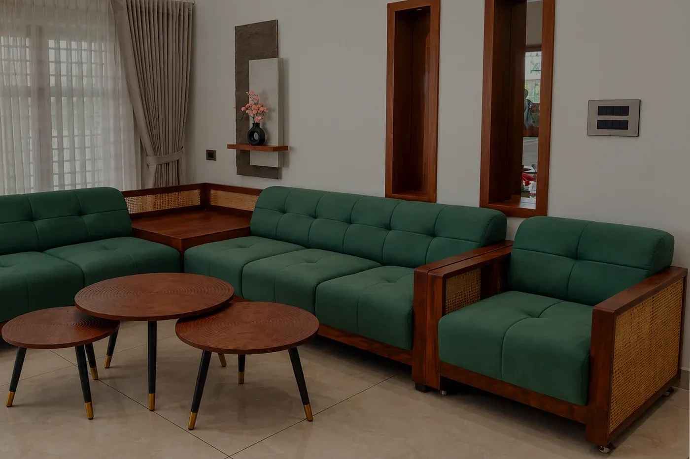 A green corner sofa with woven cane side panels in a room with sheer curtains and two tall timber wall niches.