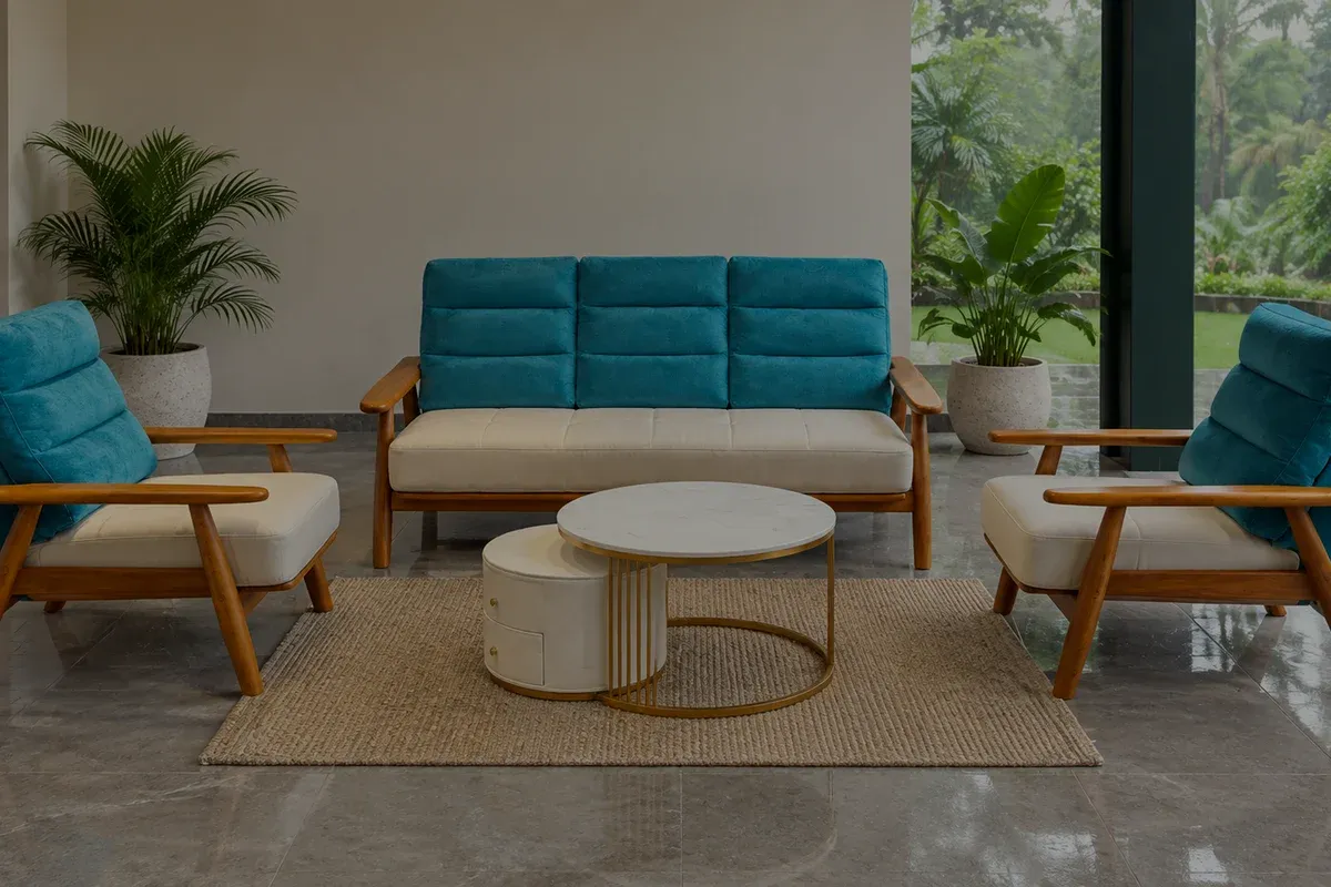 A teal and cream sofa set with a wooden frame on a polished stone floor, open to a garden along one side.